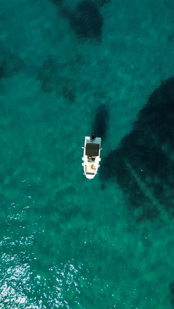 Private speedboat floating on crystal-clear turquoise water