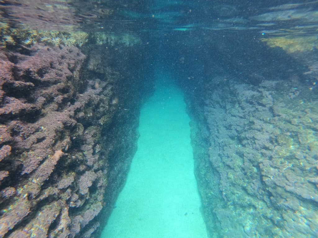 Snorkeling through a narrow underwater rocky passage
